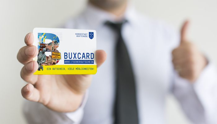 Mann hält Arbeitgebergutschein in die Kamera