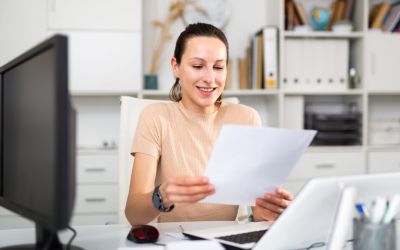 Frau liesst Dokument am Arbeitsplatz