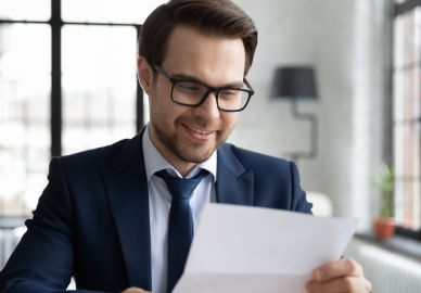 Mann mit Brille liest Dokument